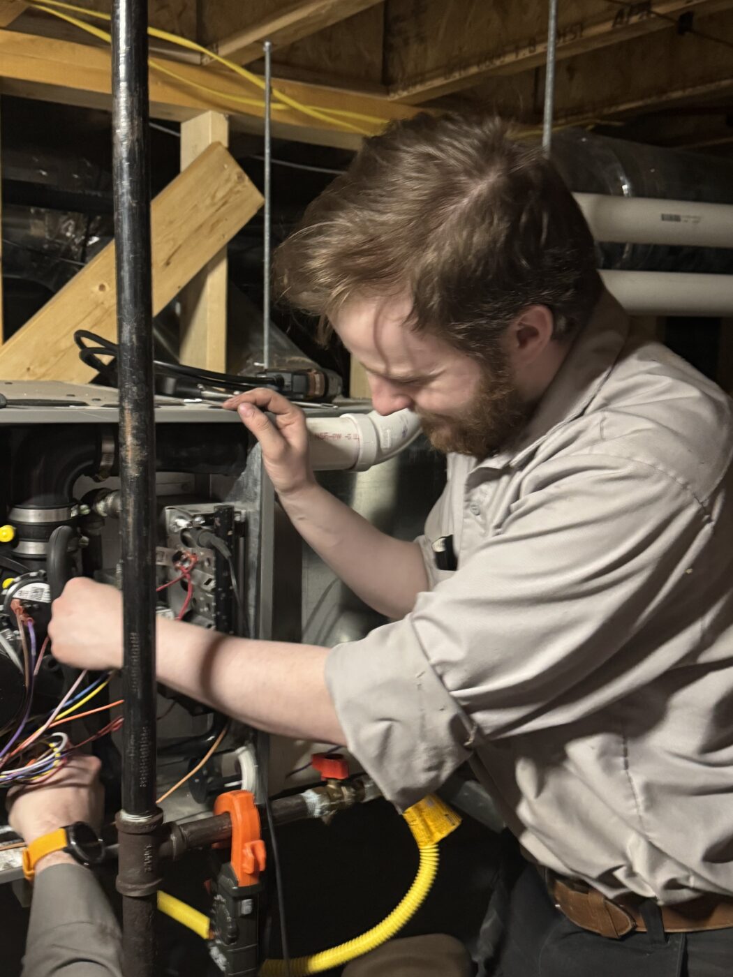 Knik Heating technician Aidan working on a heating system